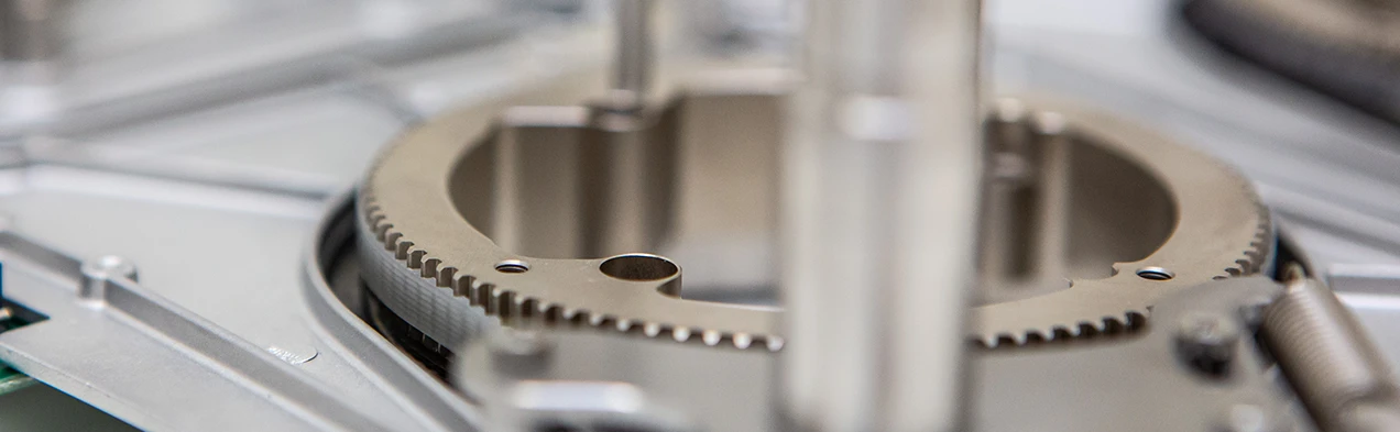 Cette image montre une vue détaillée du montage mécanique d'une courroie de distribution et d'un micro-moteur, exemplifiant la technologie de fabrication de haute précision chez Cloos Electronic. Ces composants sont essentiels pour les solutions innovantes en mécanique de précision.