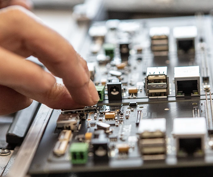 Assemblage THT sur une carte électronique déjà pré-équipée de composants SMD, illustrant la combinaison des techniques de montage en surface et de montage traversant dans l'assemblage de cartes électroniques.