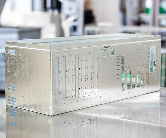 Photo d'un boîtier en tôle sur mesure par CLOOS electronic, conçu pour l'intégration d'électronique industrielle. Le boîtier est marqué par sérigraphie précise qui représente la marque et les informations techniques. La conception illustre la finition de haute qualité et la capacité d'adaptation aux exigences spécifiques des clients dans le domaine des applications électroniques industrielles.